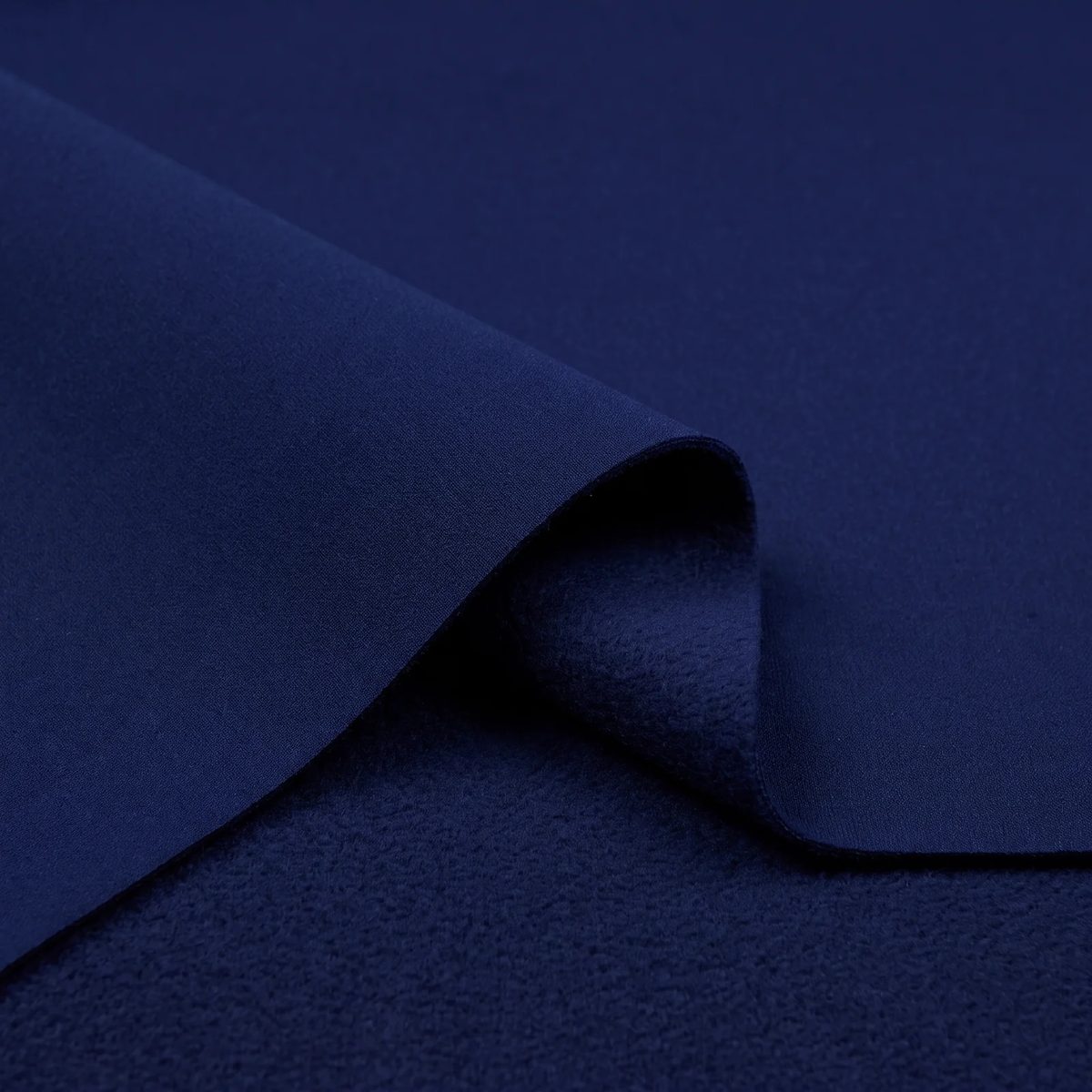 Tela antifluido térmico color azul oscuro: detalle del doblez con el borde y el perchado interior