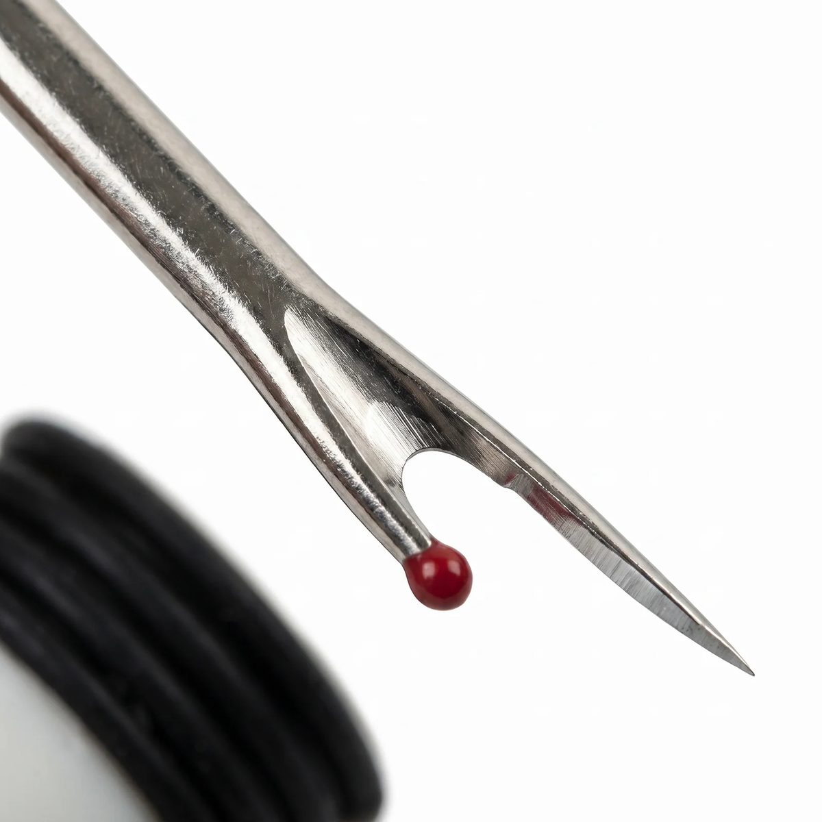 Macro de la horquilla del descosedor Clover 482/W: punta fina, filo interior y bolita roja de seguridad