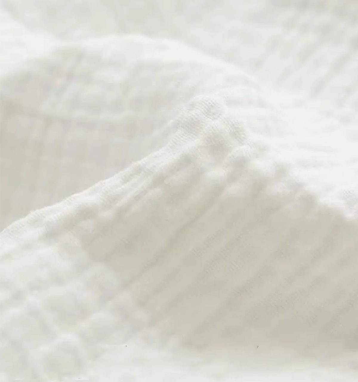 Muselina de algodón de doble gasa, color blanco, extendida para ver la textura arrugada