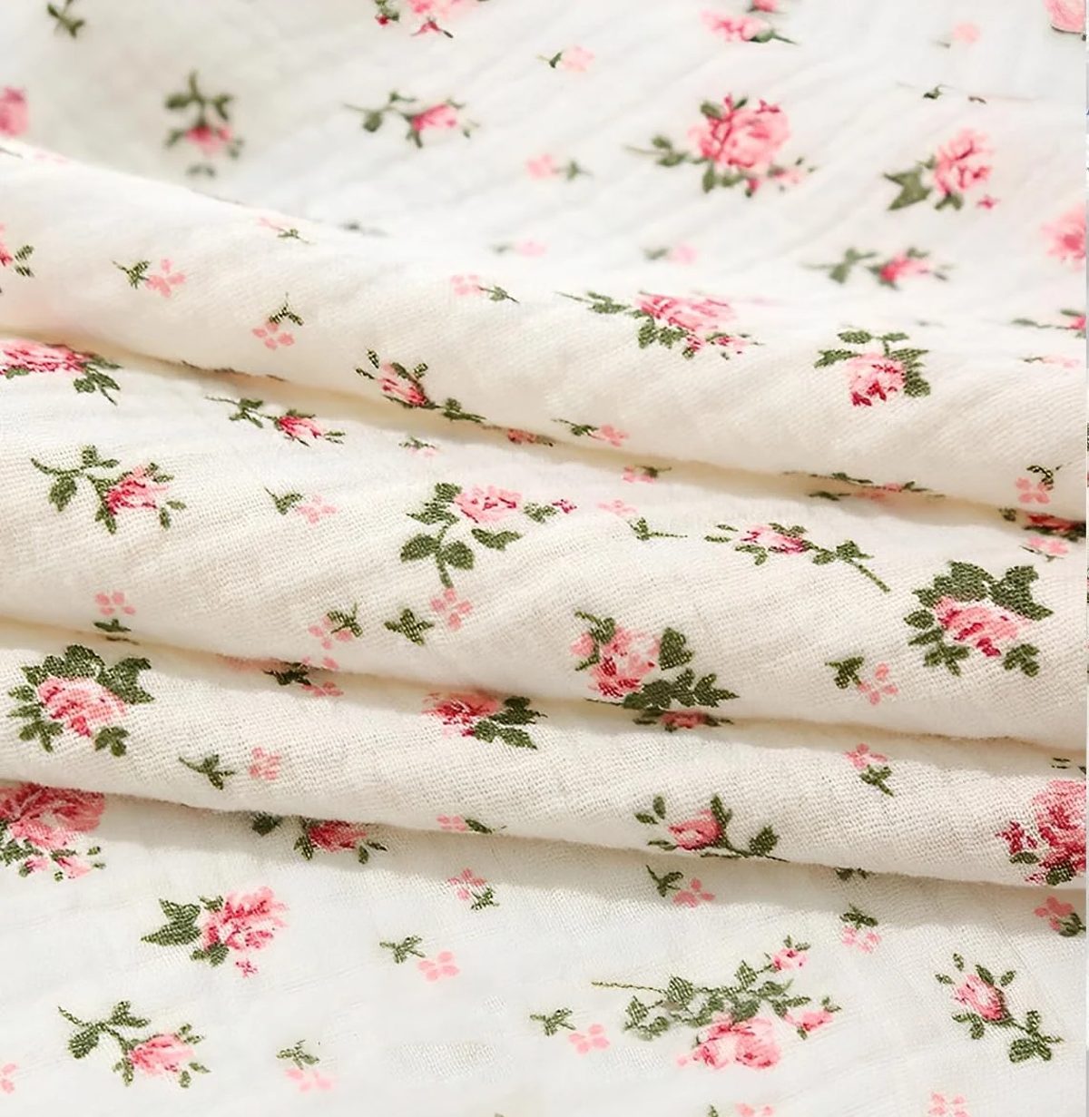 Muselina de algodón de doble gasa, color floral rosa, extendida para ver la textura arrugada